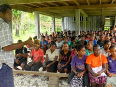 Talking to villagers during public awareness campaign